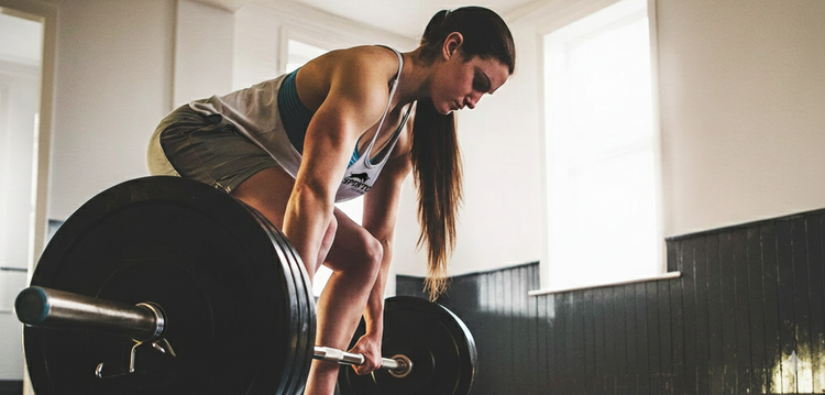 Woman lifting a barbell in a gym setting